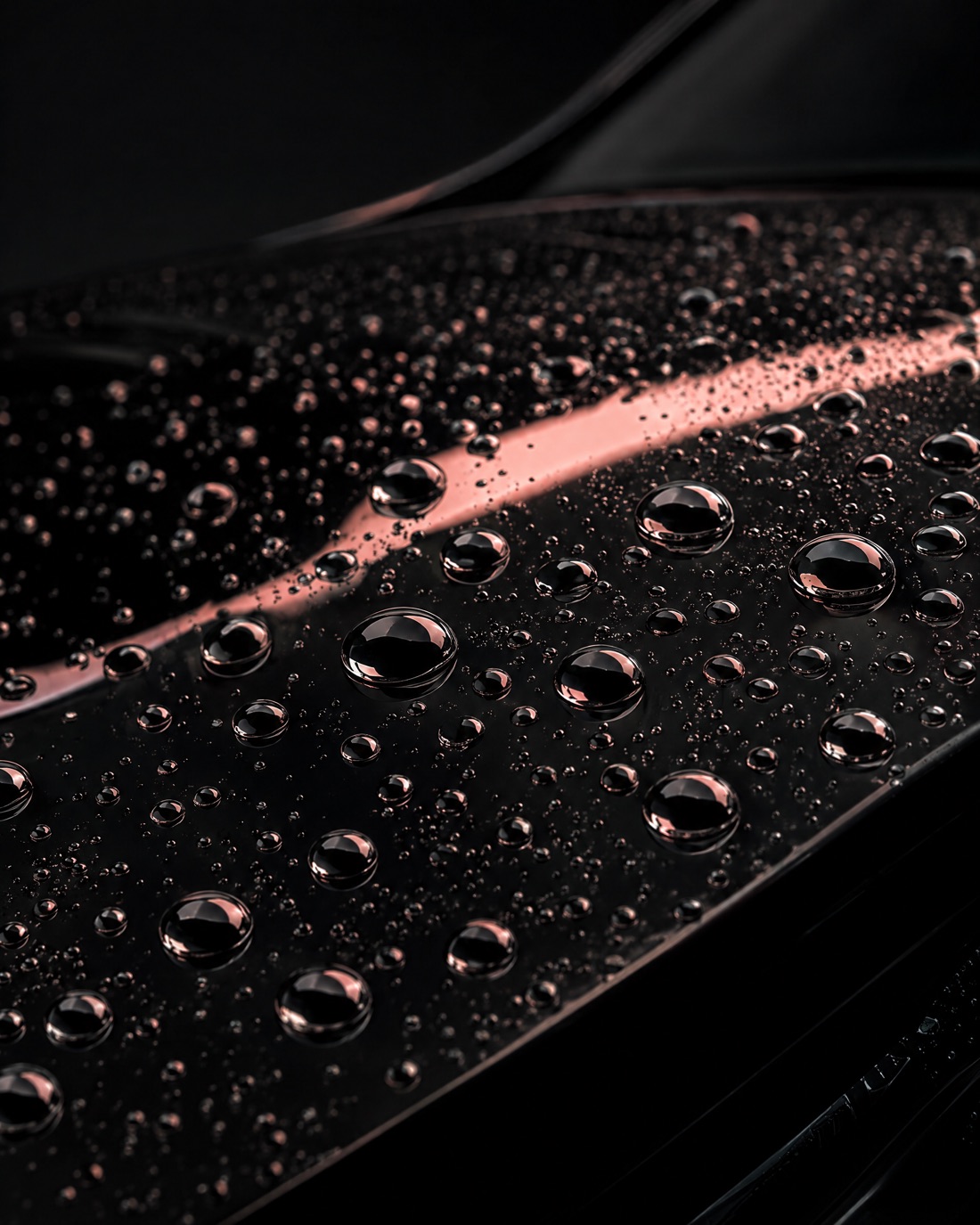 Water beading on a freshly protected black bonnet